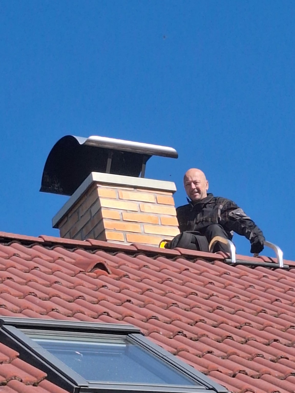 Jiří Kajzr při práci na střeše u komína