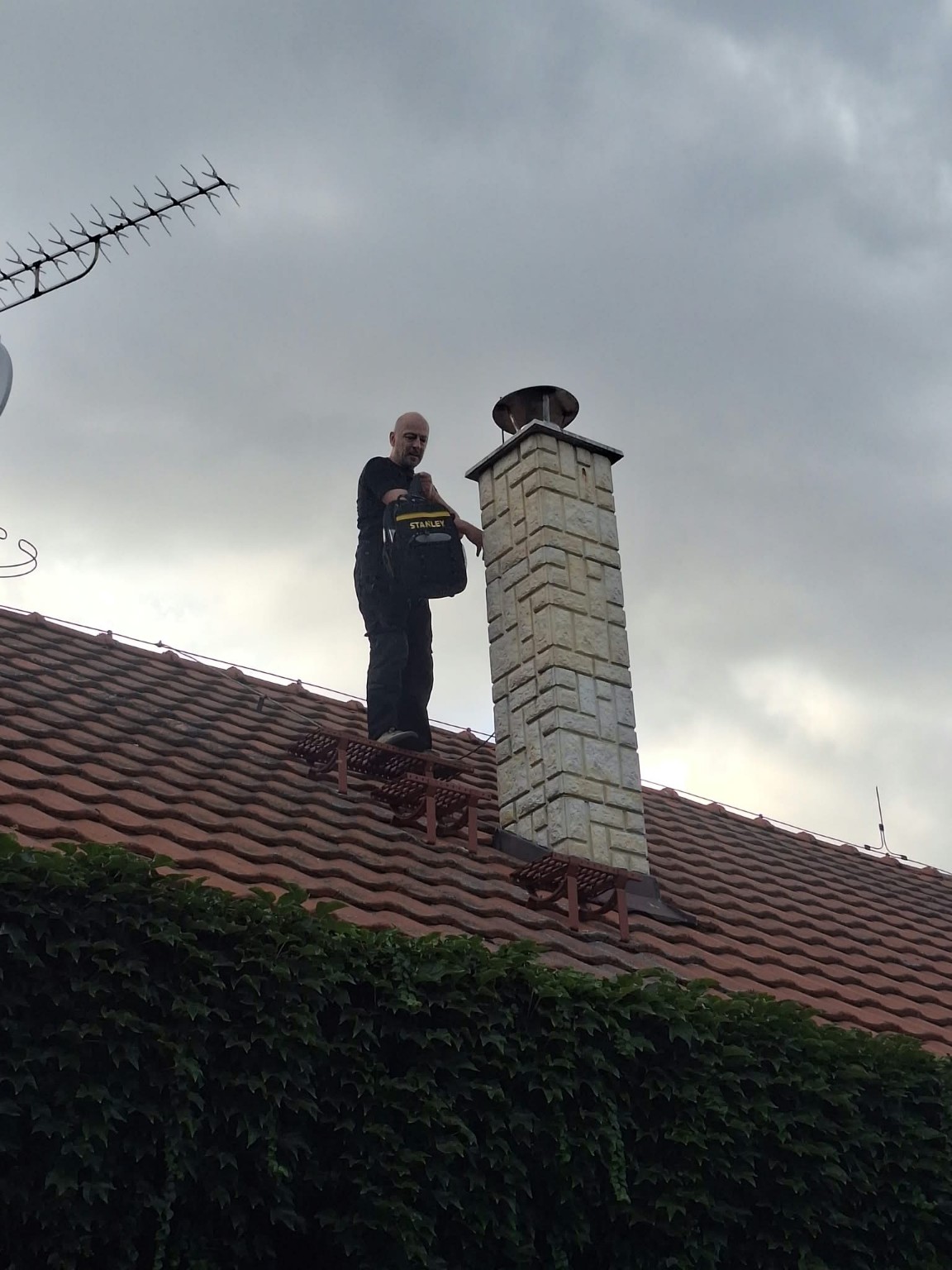 Jiří Kajzr při práci u komína na střeše